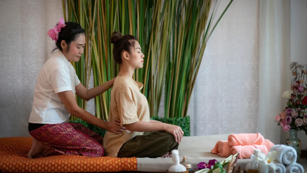 Asian Massage Therapist setting Up the Tune for an Amazing Spa Session