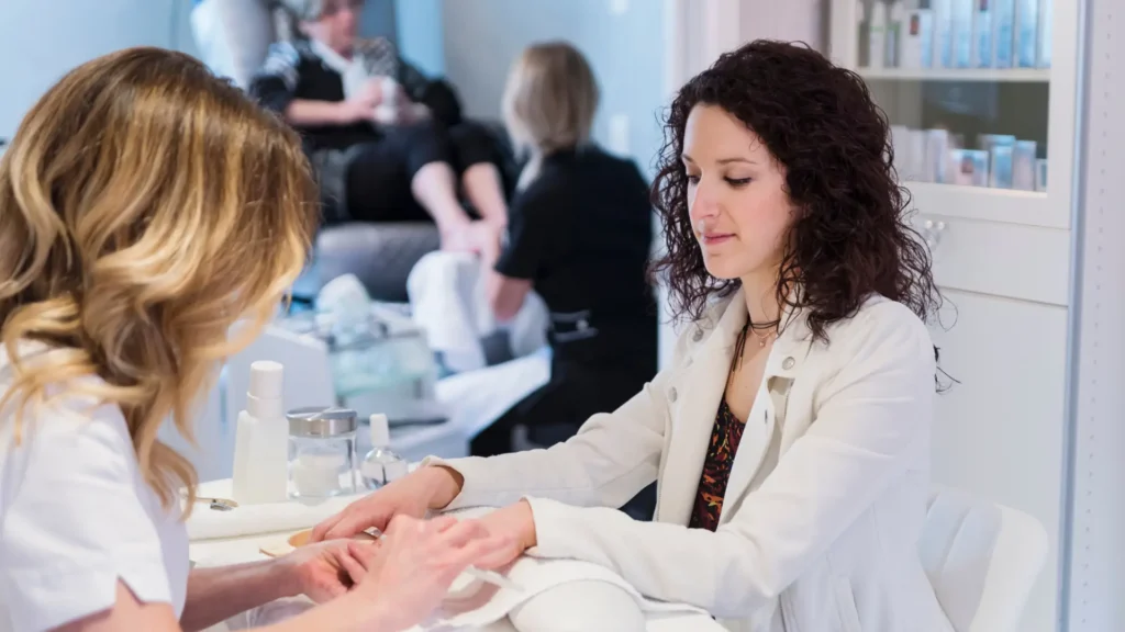 Image of manicurist performing massage on woman's hand and forearm