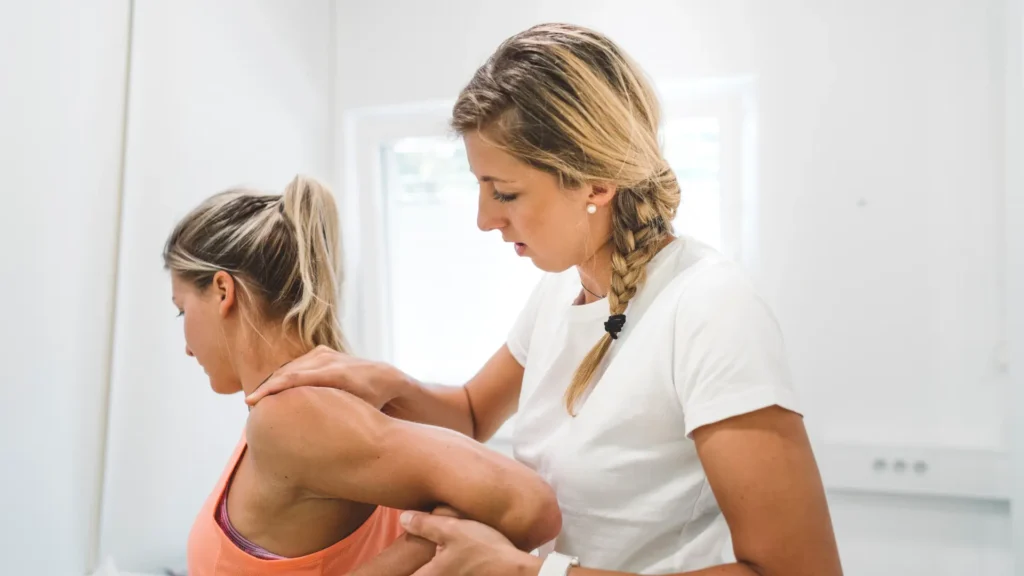 Massage therapist stretching client's arm