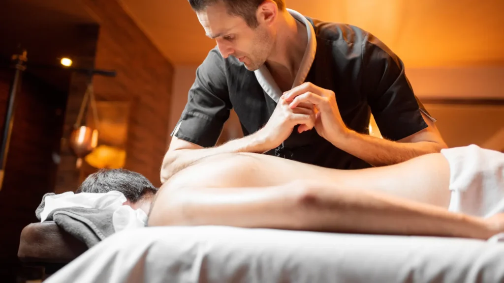 Therapist Applying body to body massage Techniques over client's back