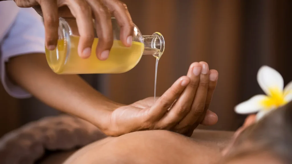Sensual massage oil being poured onto a person's back