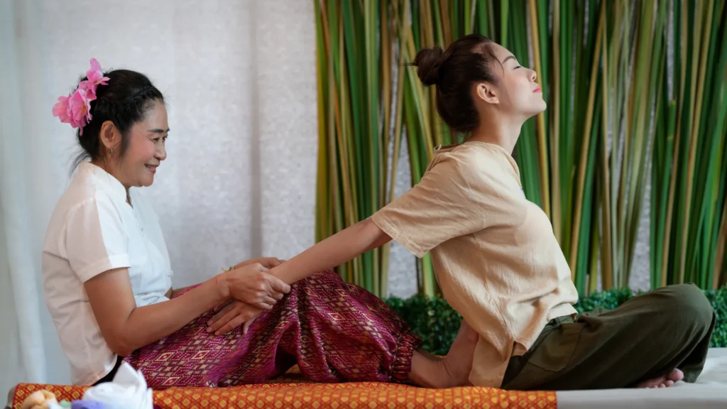 Thai Massage Expert starching her client's body for back pain relief