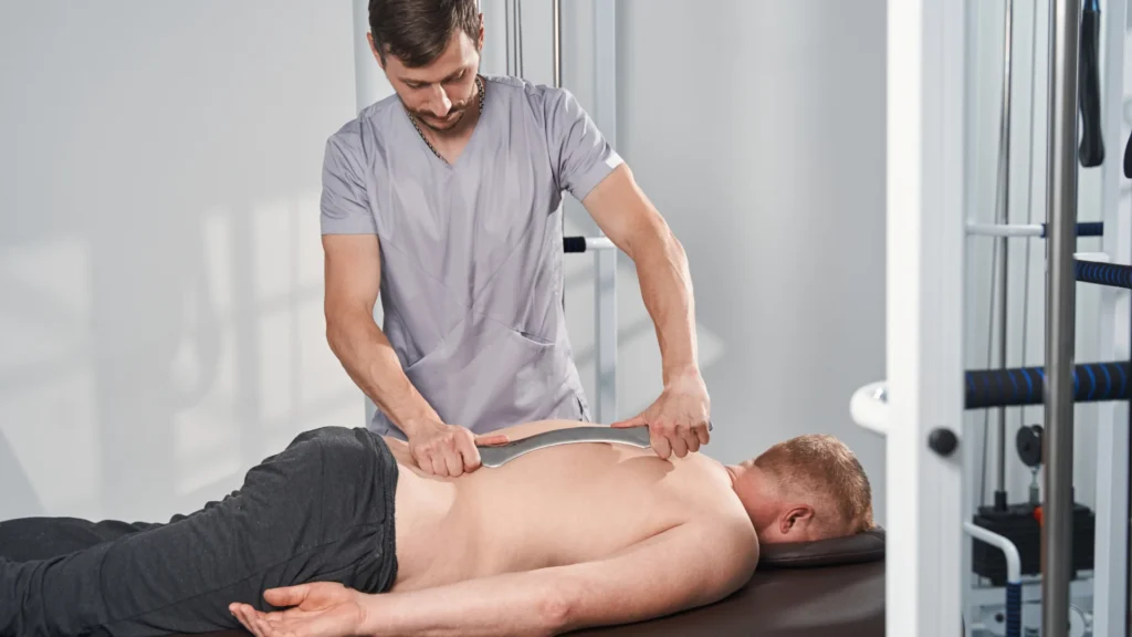 Male Therapist Applying a Special Technique to relax the Back Tissues of His Client